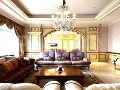 Living room with archway, purple sofa, and chandelier.