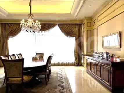 Dining room with a large dining table, chandelier, and decorative buffet.