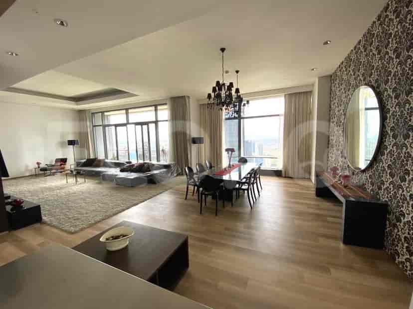 Luxurious living and dining area with a large sofa, dining table, and expansive city views.