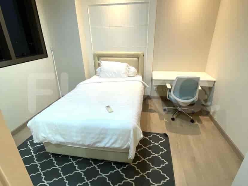 A minimalist bedroom featuring a single bed and a workspace.