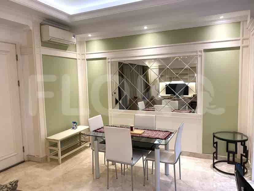 The dining area includes a glass table, modern chairs, and a wall-mounted mirror.