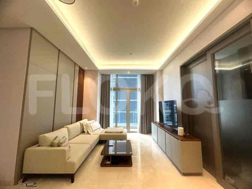 Modern living room with a grey sofa, TV, and city view.