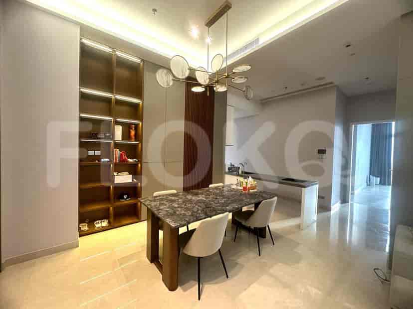 Dining area with table and chandelier, and a kitchen with island.