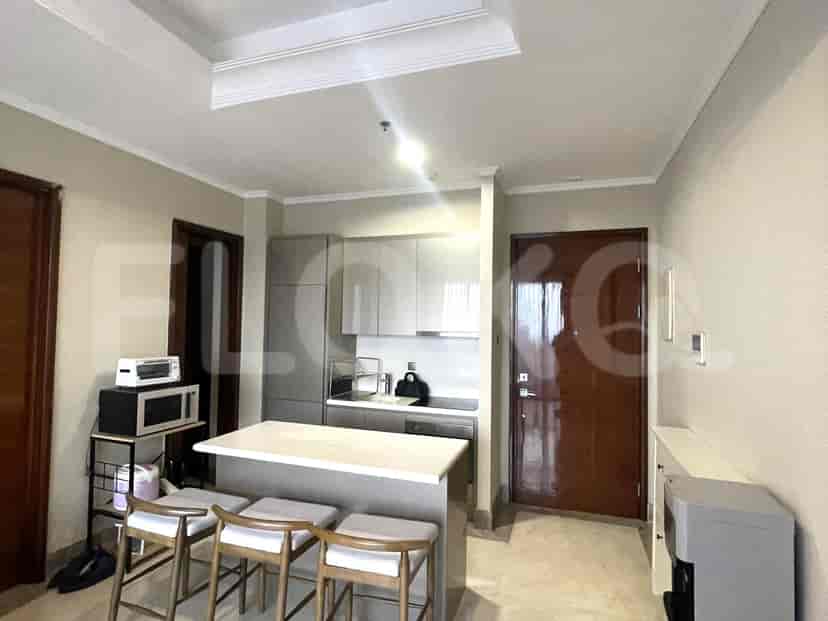 Dapur modern dengan meja sarapan, peralatan stainless steel, dan lemari abu-abu muda.