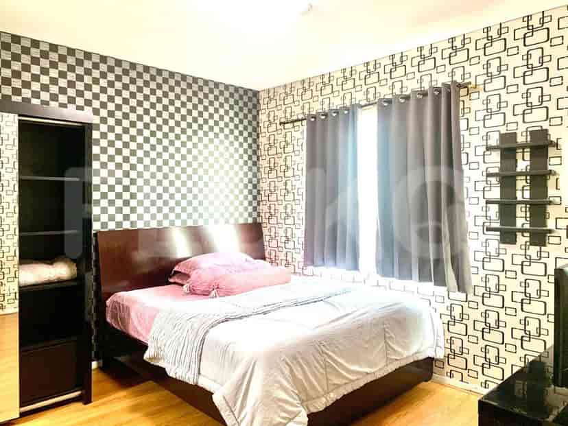 Kamar tidur dengan tempat tidur besar, wallpaper bermotif, dan lemari pakaian.