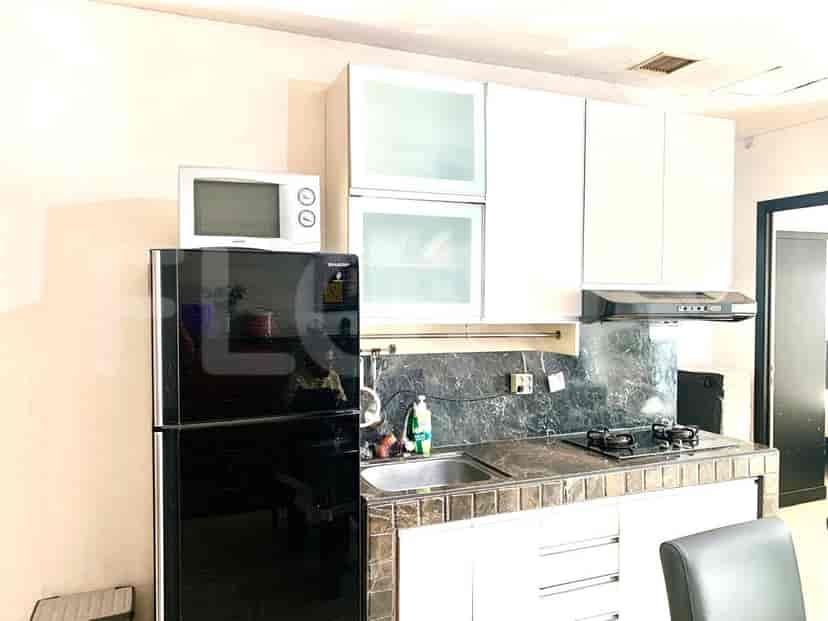 Dapur modern yang menampilkan lemari es, microwave, dan permukaan memasak.