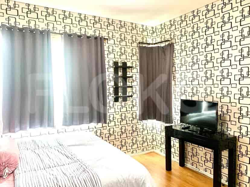 Kamar tidur dengan tempat tidur, gorden, dan rak TV.