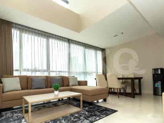 A well-lit living room with a comfortable L-shaped sofa, large windows, and a modern aesthetic.