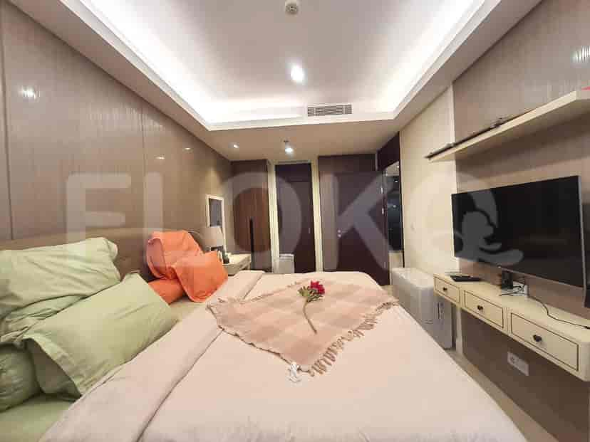 A spacious bedroom with a large bed and wall-mounted TV.