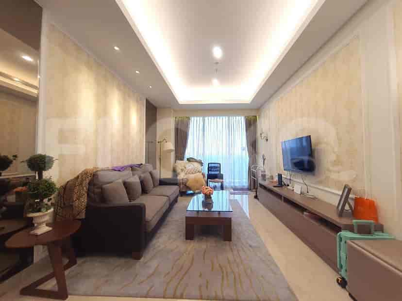 The living room with sofa, curtains, TV, and carpet.