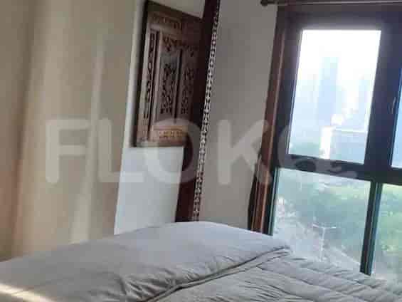 Bedroom with a large window, bed, and decorative wall piece.