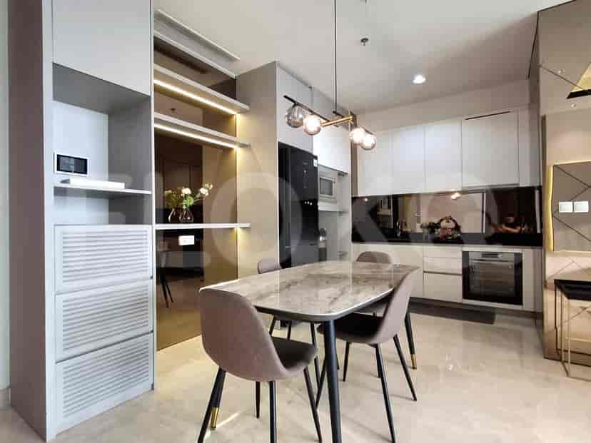 Dapur dan ruang makan modern dengan meja marmer dan lemari yang ramping.