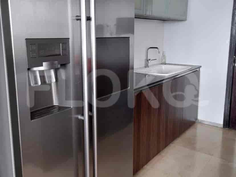 A kitchen with a refrigerator, cabinets and sink area.