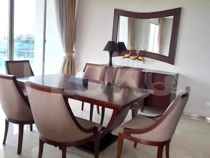 Elegant dining room with a wooden table, six chairs, and a large mirror.
