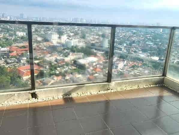 Balcony with glass railings overlooking a cityscape.