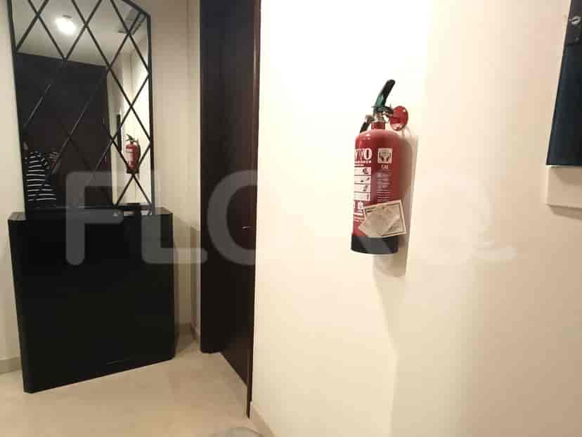 A hallway with a fire extinguisher and an entry mirror.