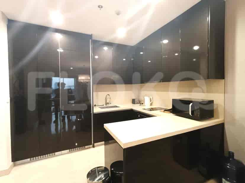 A sleek, modern kitchen with dark cabinetry and a breakfast bar.