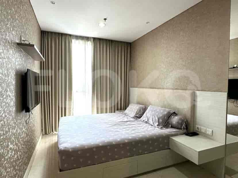 Bedroom with a bed, a mirror, and a wall-mounted TV.