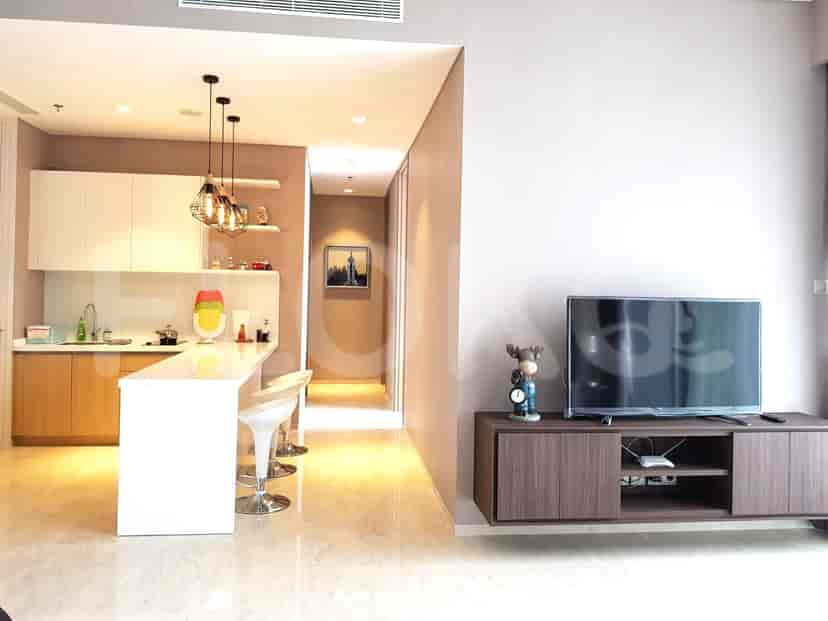 Modern open kitchen and living area, featuring a flat-screen TV and contemporary design.