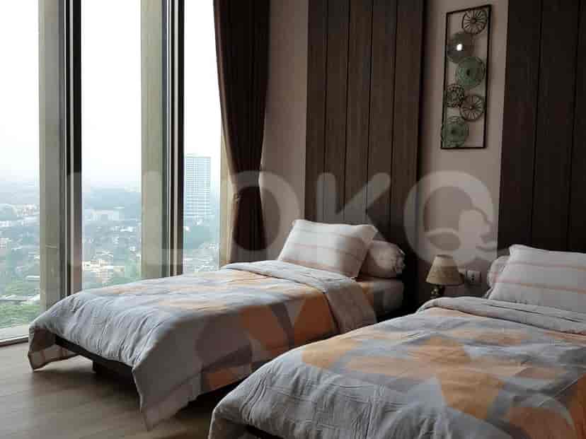 Bedroom with twin beds, a large window offering a city view, and modern decor.
