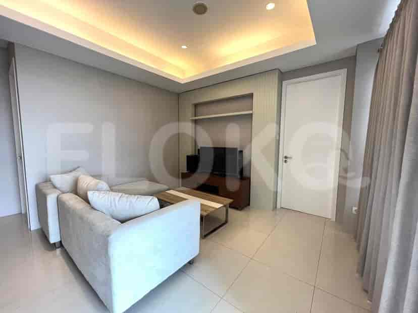 Area ruang tamu modern dengan sofa berbentuk L, TV, dan meja kopi kayu.