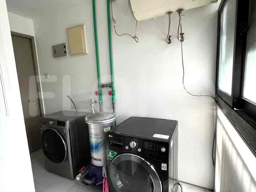 Area binatu fungsional dengan mesin cuci dan pengering.
