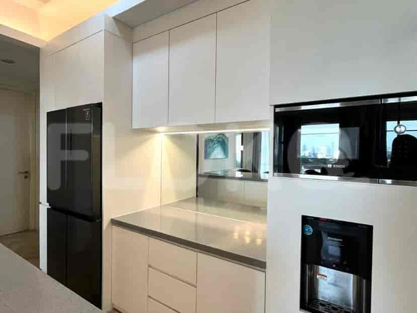 Modern kitchen with a black refrigerator, built-in appliances, and light countertops.
