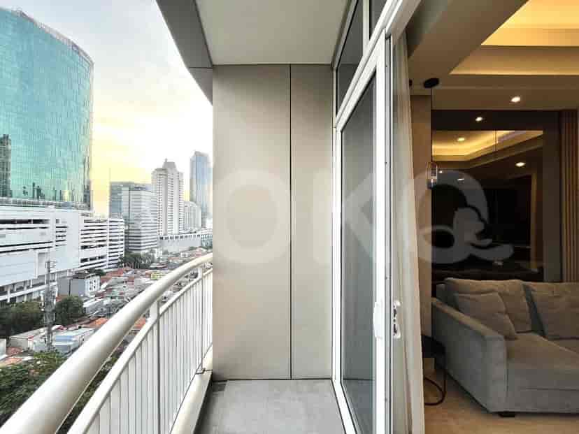 A balcony overlooking a city, accessible from the living room.