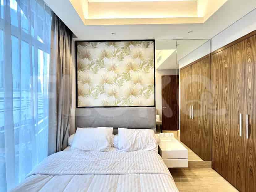 A modern bedroom featuring a bed, closet, and cityscape view.