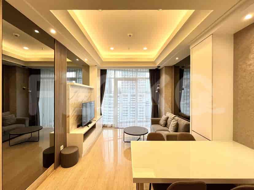 A modern living room featuring a sofa, TV, and dining area with a city view.