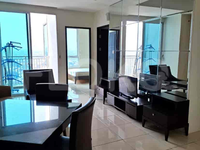 Living room with a dining table, TV console, and mirrored wall.