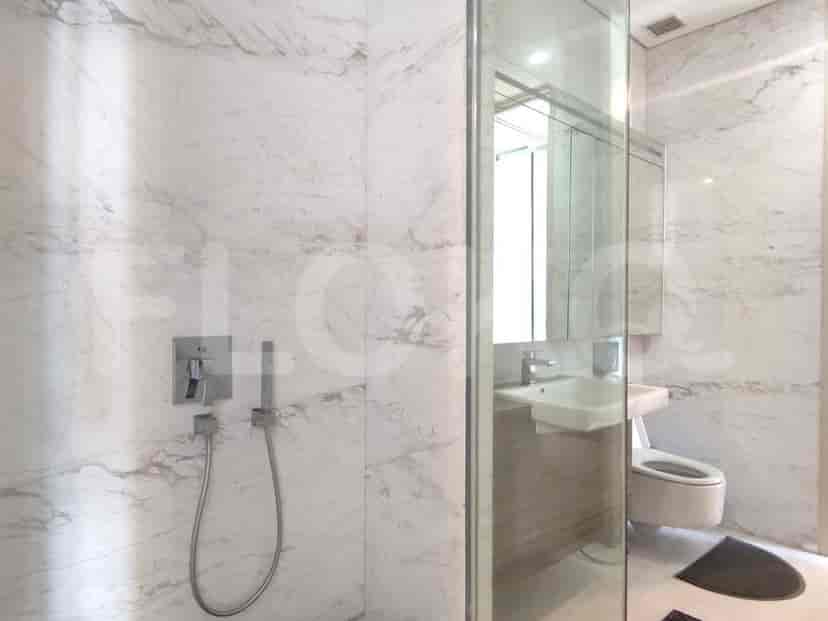 Kamar mandi modern dengan shower dan estetika yang bersih.