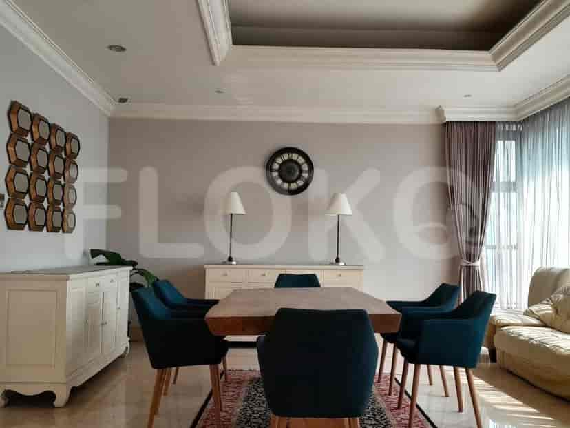 A dining room with a wooden dining table, blue chairs, and elegant lighting.