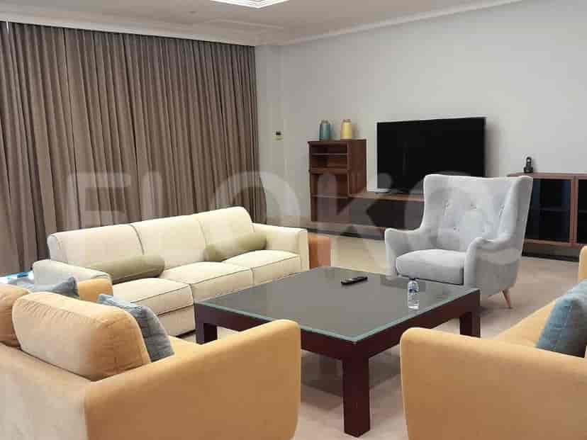 A modern living room with a cream sofa, a dark coffee table, and a TV.
