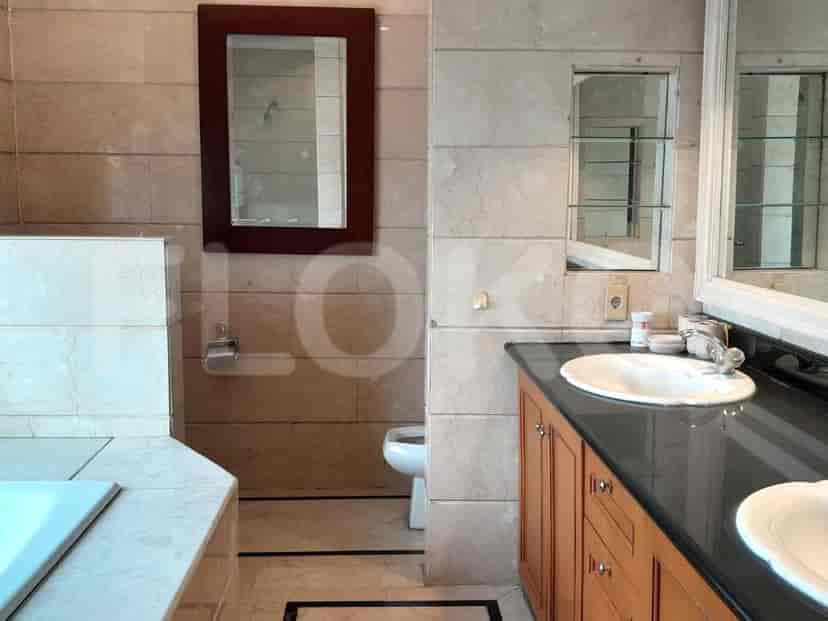 A spacious bathroom with a vanity, mirror, and a toilet.