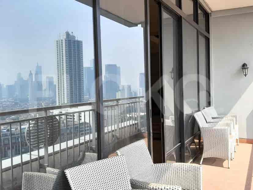 A balcony with outdoor furniture, offering views of the city skyline.