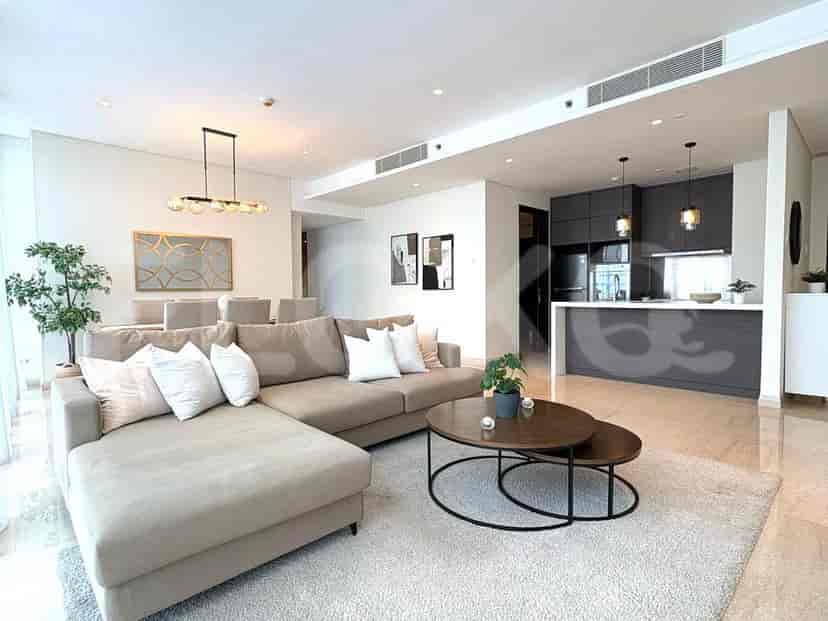 Open-plan living space with a large L-shaped sofa, dining area, and open kitchen.