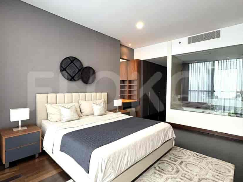 Modern bedroom with a bed, bedside tables, and access to a private bathroom.