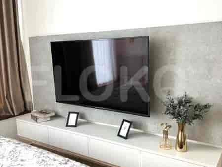 Bedroom with a TV, artwork, and storage.