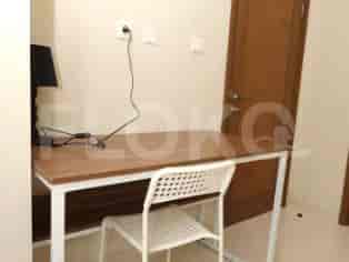 A bedroom with a desk, chair, and door.