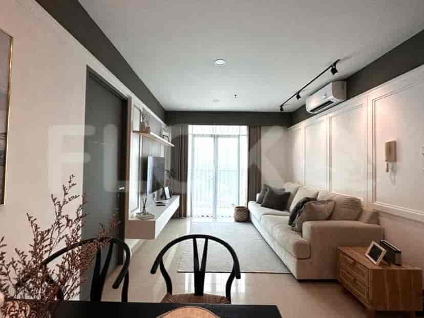 A modern living space with a grey sofa, mounted TV, dining table with chairs, and a view of the city.