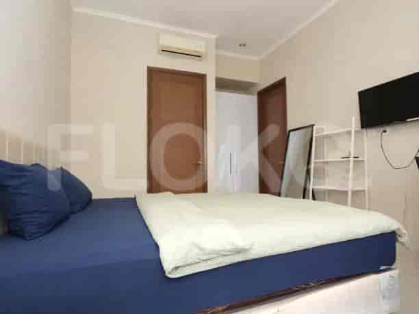 A bedroom with a double bed, mirror, and door.