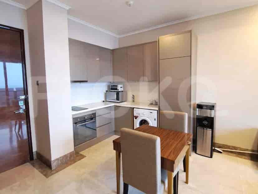 A modern kitchen with stylish gray cabinets, a built-in oven, and essential appliances.