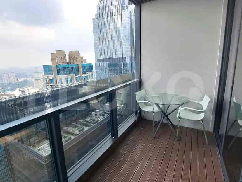 A balcony overlooking the city with chairs and a table, offering a relaxation spot with a view.