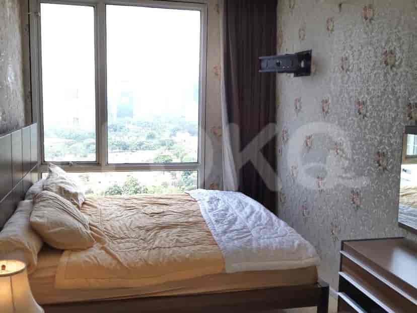 Cozy bedroom with a bed, large window and floral wallpaper.