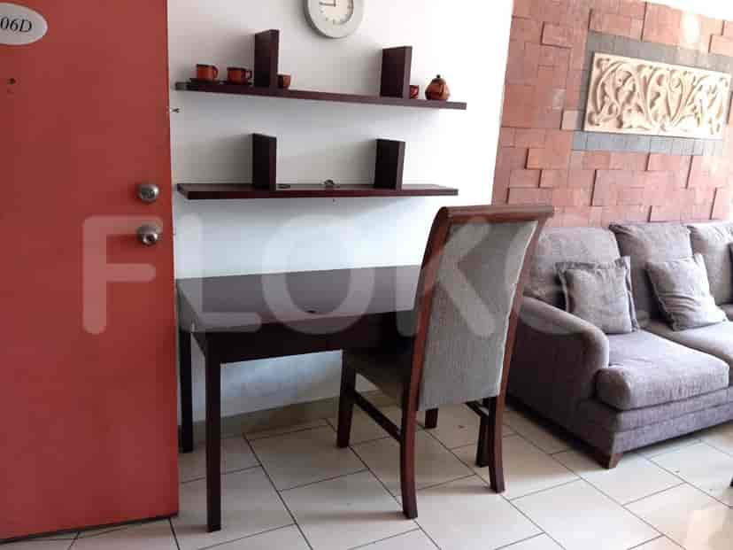 A small home office area with a desk, chair, and floating shelves.