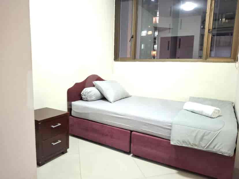 A compact bedroom featuring a single bed and a nightstand.