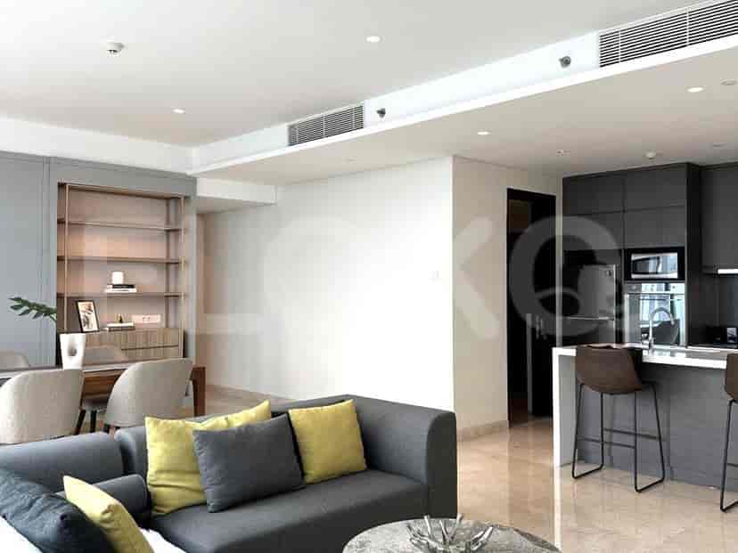 Living room with kitchen bar, featuring a grey sofa, dining area with grey chairs, and an open kitchen layout.