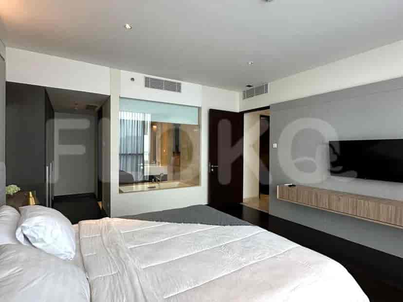 Master bedroom with a bed, bathroom access, and a wall-mounted TV.