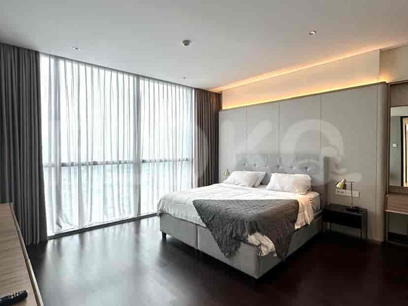 Bedroom with floor-to-ceiling windows, offering plenty of natural light, a bed, and dark wooden flooring.